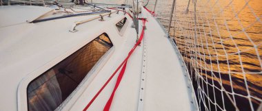 Fırtınadan sonra beyaz yat yola çıkıyor. Direk görüntüsü, yelkenler, donanım. 9 metre İsviçre yapımı seyyar yelkenli. Yaz tatilleri, dinlenme, spor, boş zaman aktiviteleri.