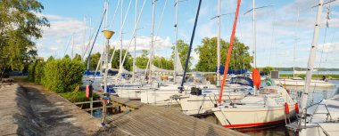 Zarif ve modern yelkenliler yat limanındaki bir rıhtıma demirlediler. Yaz tatilleri, turizm, yat, dinlenme, spor, boş zaman aktiviteleri, yarış, yelkencilik, yaşam tarzı.