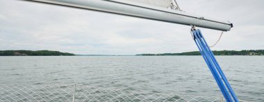 Fırtınada beyaz yat denize açılıyor. Direk görüntüsü, yelkenler, donanım. 9 metre İsviçre yapımı seyyar yelkenli. Yaz tatilleri, dinlenme, spor, boş zaman aktiviteleri.