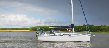 Açık bir günde beyaz yelkenli tekneyle denize açılmak. Yaz tatilleri, ulaşım, turizm, gezi, dinlenme, spor, eğlence aktivitesi, yarış, yelkencilik, yaşam tarzı.