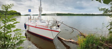 Kayalık kıyıya demir atmış bir yat. 9 metre İsviçre yapımı seyyar yelkenli. İsveç. Doğa, yaz tatilleri, eğlence, gezi, spor, ulaşım, eko-turizm