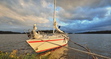 Kayalık kıyıya demir atmış bir yat. 9 metre İsviçre yapımı seyyar yelkenli. İsveç. Doğa, yaz tatilleri, eğlence, gezi, spor, ulaşım, eko-turizm