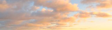 Açık mavi gökyüzü. Pembe ve altın rengi sirrus ve kümülüs bulutları fırtına üstüne, yumuşak güneş ışığı. Dramatik gün batımı bulutları. Meteoroloji, cennet, barış, grafik kaynakları, pitoresk panoramik manzara