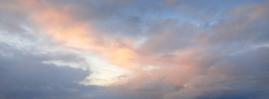 Fırtınadan sonra parlayan pembe ve altın bulutlu açık mavi gökyüzü. Dramatik gün batımı bulutları. Sanat, meteoroloji, cennet, umut, barış kavramları. Grafiksel kaynaklar, resimsel panoramik manzara