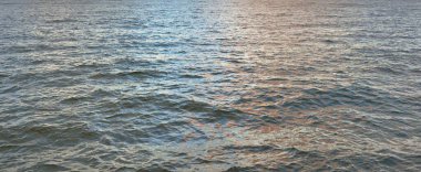 Gün batımında açık Baltık denizinin panoramik görüntüsü. Su yüzeyi dokusu, dalgalar. Dengesiz hava, kış, iklim değişikliği, okyanus kabarması, doğa.