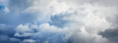 Süslü bulutlar. Dramatik bir gökyüzü. Destansı fırtına bulutları. Yumuşak güneş ışığı. Panoramik görüntü, doku, arkaplan, grafik kaynakları, tasarım, kopyalama alanı. Meteoroloji, cennet, umut, barış kavramı