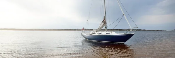 Niebieski Sloop Uzbrojony Jacht Zakotwiczony Płytkiej Wodzie Pobliżu Piaszczystego Brzegu — Zdjęcie stockowe
