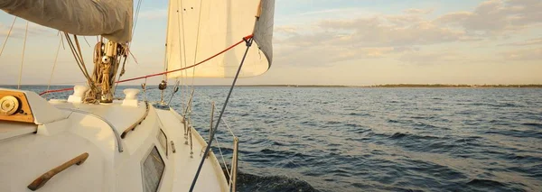 白いスループは 日没時に海を航海するヨットを操縦しました 澄んだ空 デッキから弓 マスト 帆への眺め クルーズ スポーツ レクリエーション レジャー活動 — ストック写真