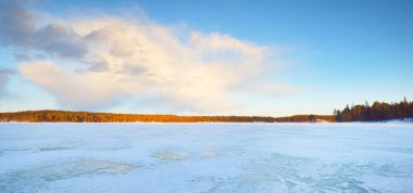 Gün batımında donmuş göl ve karla kaplı çam ormanı. Buz dokusu. Dramatik gökyüzü, pembe bulutlar. Kış Harikalar Diyarı. Doğa, çevre koruma, ekoloji, iklim değişikliği, eko-turizm, Noel