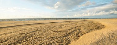 Destansı kümülüs bulutları, fırtınadan sonra kumlu Baltık deniz kıyısında. Kuru nehir, yakın çekim kum dokusu. - Letonya. Dramatik bir gökyüzü. Ekoloji, çevre koruma, kararsız hava, iklim değişikliği