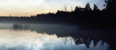 Finlandiya 'nın Saimaa Gölü üzerinde yaz gündönümü gecesinde, gece parlayan bulutlar ve sis ile yıldızlı gökyüzü. Uzun pozlama. Simetri yansımaları, doğal ayna. Mistik manzara, pagan kutlaması.