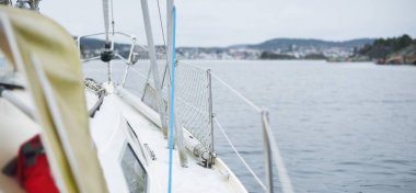 Fırtınadan sonra yat kalkıyor. Güverteden pruvaya yakın görüntü, direk, yelkenler. Dramatik gökyüzü, kara bulutlar. Kuzey denizi, Norveç. Kötü hava, kasırga. Eğlence, eğlence aktivitesi, spor, yelkenli yarışı.