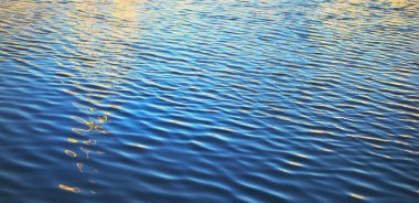 Su yüzeyi dokusu. Mavi, gök mavisi, turkuaz renkler. Altın güneş ışığı, gün doğumu. Soyut doğal desen, arka plan, duvar kağıdı. Grafiksel kaynaklar, kopyalama alanı. Kuzey denizi, Norveç