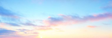 Açık mavi gökyüzü. Pembe ve altın rengi sirrus ve kümülüs bulutları fırtına üstüne, yumuşak güneş ışığı. Dramatik gün batımı bulutları. Meteoroloji, cennet, barış, grafik kaynakları, pitoresk panoramik manzara