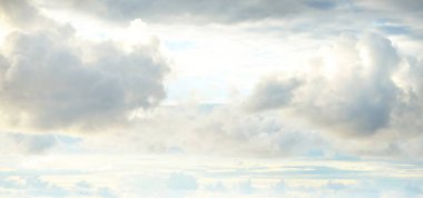 Süslü bulutlar. Dramatik bir gökyüzü. Destansı fırtına bulutları. Yumuşak güneş ışığı. Panoramik görüntü, doku, arkaplan, grafik kaynakları, tasarım, kopyalama alanı. Meteoroloji, cennet, umut, barış kavramı