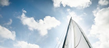 Beyaz yat bulutlu açık mavi gökyüzüne doğru yelken açıyor. Açık bir Akdeniz 'de yelken açmak. Idyllic bulut manzarası. Yaz tatilleri, boş zaman aktiviteleri, spor ve eğlence, özel gelincik.