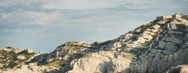 Kayalık kıyılar (uçurumlar) yakın çekim, yelkenli teknenin manzarası. Frioul takımadaları, Akdeniz, Marsilya Körfezi, Fransa. Seyahat yerleri, ulusal dönüm noktaları, geziler, tatiller.