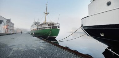 Şehir merkezindeki bir rıhtıma demirlemiş yeşil eğitim gemisi. Stavanger seti, Norveç. Seyahat yerleri, turizm, turizm, gezi, yelkenli yarışı, keşif, araştırma, iş, geleneksel zanaat.