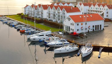Yat marinasının panoramik hava manzarası, fayanslı çatıları olan modern geleneksel evler, sahte kırmızı boya. Stavanger, Rogaland bölgesi, Norveç. Mimarlık, seyahat merkezleri, turizm, yelkencilik, seyahat
