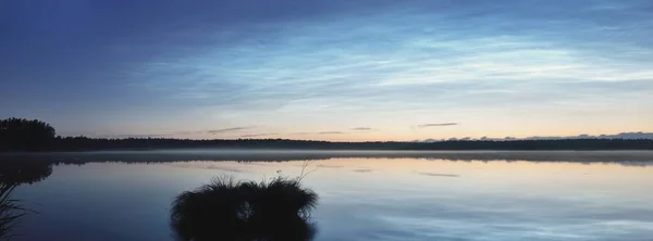 夏至の夜には サイマー湖の上に雲や霧が立ち込めて星空を眺めることができます 黄金の太陽 長時間露光 壮大な雲の風景 自然パターンだ 水の対称性の反射 フィンランド — ストック写真