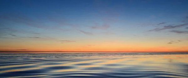 波罗的海 戏剧化的日落天空 闪耀的粉色和金色的云彩 对称的反光在水中 摘要自然图样 风景如画的全景 — 图库照片
