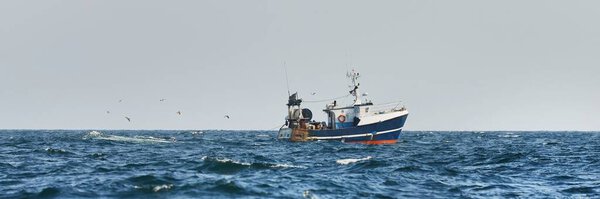 Маленькая рыбацкая лодка, плавающая в открытом Средиземном море, крупным планом. Вид с яхты. Отдых, спорт и отдых, пищевая промышленность, традиционные ремесла, экологические концепции ущерба