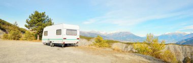 Karavan karavanı, bisiklet ve araba bir dağın tepesine park edilmiş. Fransız Alpleri 'nde, Lac de Serre-Poncon Gölü yakınlarında. Ulaşım, karavan, karavan, yol gezisi, kamp, turizm, eğlence, yaşam tarzı