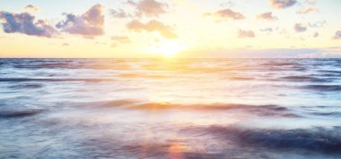 Gök gürültülü bir fırtınadan sonra denizin üstünde destansı pembe gün batımı bulutları. Dramatik bir gökyüzü. Dalgalar ve su dokuya sıçrar. Idyllic deniz manzarası. Kavramsal görüntü, uzun pozlama. Resim gibi bir manzara.