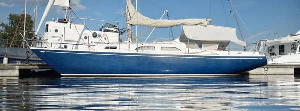 经典的蓝色单桅游艇停泊在有遮阳篷的码头上 巡航生活 帆船旅行 休闲活动 水面纹理 — 图库照片