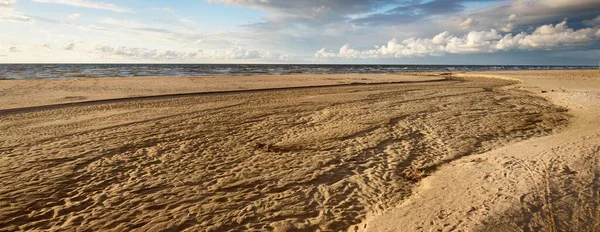 Destansı kümülüs bulutları, fırtınadan sonra kumlu Baltık deniz kıyısında. Kuru nehir, yakın çekim kum dokusu. - Letonya. Dramatik bir gökyüzü. Ekoloji, çevre koruma, kararsız hava, iklim değişikliği