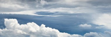 Süslü bulutlar. Dramatik bir gökyüzü. Destansı fırtına bulutları. Yumuşak güneş ışığı. Panoramik görüntü, doku, arkaplan, grafik kaynakları, tasarım, kopyalama alanı. Meteoroloji, cennet, umut, barış kavramı