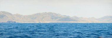 Akdeniz üzerinde kümülüs bulutları olan açık mavi gökyüzü, kayalık kıyılar (uçurumlar, dağ zirveleri) yakın çekim. İspanya kıyıları. Idyllic deniz manzarası. Seyahat yerleri, seyahat, dinlenme, çevre