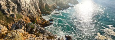 Pointe de Pen-Hir 'in kayalık sahili, uçurumlara yakın. Gök mavisi su, fırtınalı dalgalar. Dramatik bulut manzarası. Crozon Yarımadası, Britanya, Fransa