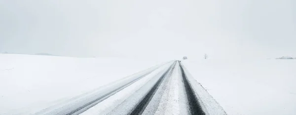 눈보라가 지나간 안개가 지형을 통과하는 눈덮인 고속도로 아스팔트 온난화 생태계 — 스톡 사진