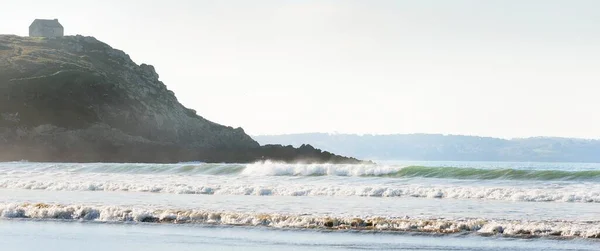 崖の上の孤独な伝統的な家 ドゥアルネネス湾の砂浜の海岸からの眺め 真っ青な空 波と水が飛び散った フランスのブルターニュ 旅行先 観光テーマ — ストック写真