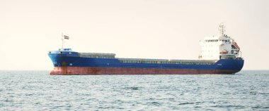 Cebelitarık Boğazı 'nda demirli büyük mavi bir kargo gemisi. Yat manzaralı, yakın plan. Yaz Atlantik 'i İspanya ve Afrika' ya doğru gidiyor. Açık mavi gökyüzü