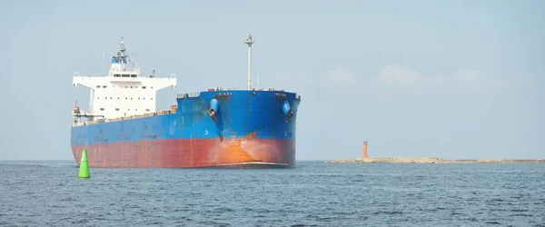 バルト海の大きな青いばら積み貨物船 がラトビアのリガ港まで航行しています ヨットからの眺め 貨物全般 グローバル通信 貨物輸送 — ストック写真