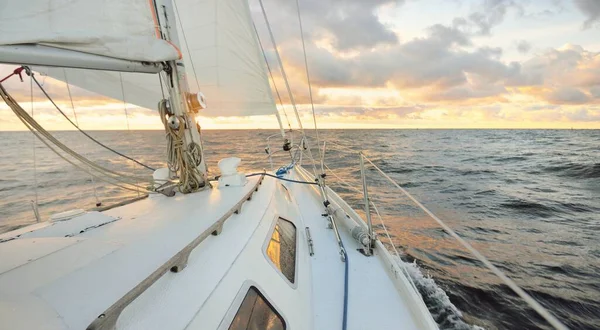 日落时 游艇在开阔的海面上航行 桅杆和帆的近景 雨后的晴空 戏剧性的云彩 金色的阳光 浪花和水花 史诗般的海景 — 图库照片