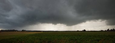 Yağmurdan sonra tarla tarlası. Dramatik gökyüzü, destansı bulutlar. Hava kararsız. - Letonya. Kasırga, fırtına, meteoroloji, ekoloji, iklim değişikliği, doğal olaylar