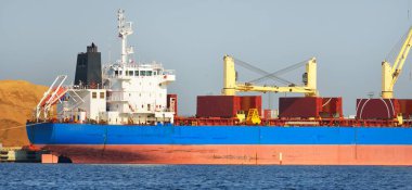 Kömür terminalinde büyük bir kargo gemisi (kargo gemisi), yakın plan. Arka planda iskele vinçleri. Krievu Adası, Riga, Letonya. Yük taşımacılığı, yakıt ve enerji üretimi, çevresel hasar