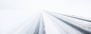Kar fırtınası sonrasında kırsal alanlarda karla kaplı otoyol (asfalt yol) sisli bir havada. Tehlikeli sürüş, iklim değişikliği, küresel ısınma, ekoloji, çevre koruma