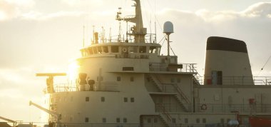 Sovyet buzkıranı dramatik günbatımı bulutları altında açık denizde. Yük taşımacılığı, küresel iletişim ve güvenlik, yakıt ve güç üretimi, sanayi, lojistik, araştırma, keşif