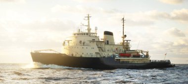 Sovyet buzkıranı dramatik günbatımı bulutları altında açık denizde. Yük taşımacılığı, küresel iletişim ve güvenlik, yakıt ve güç üretimi, sanayi, lojistik, araştırma, keşif