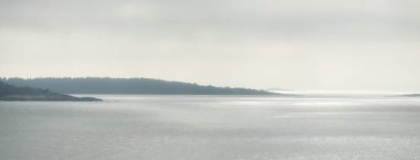Fırtına sırasında Baltık Denizi 'nin panoramik görüntüsü. Dramatik gökyüzü, kara bulutların arasından güneş ışınları. Destansı deniz manzarası. Finlandiya. Görüntü, ekoloji, meteoroloji, hava durumu. Siyah ve beyaz, gümüş renkler