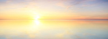 Yağmurdan sonra Baltık Denizi. Dramatik günbatımı gökyüzü, parlayan pembe ve altın bulutlar, suda simetri yansımaları. Soyut doğal desen, doku, arka plan. Resimli panoramik manzara