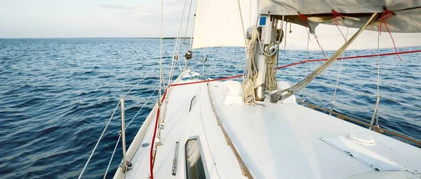 白いスループは 日没時に海を航海するヨットを操縦しました 澄んだ空 デッキから弓 マスト 帆への眺め クルーズ スポーツ レクリエーション レジャー活動 — ストック写真
