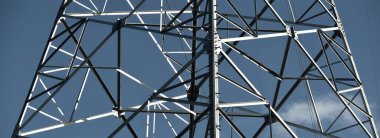 Elektrik hattı açık mavi gökyüzüne karşı, yakın plan. Şehir manzarası kavramı. Enerji, enerji üretimi, özel ekipman, endüstri, çevresel hasar, ekoloji, altyapı, ormanların tahrip