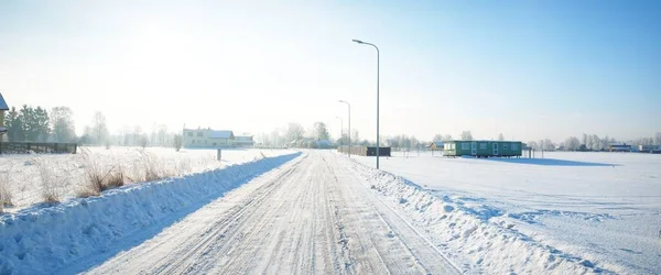 雪の村を介してカントリーロード覆われた 霜で背の高い木 新鮮な雪の中で車のトラック 提灯を閉じます 晴れた冬の日 ラトビア — ストック写真