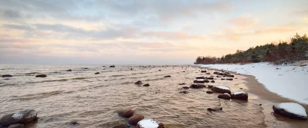 Widok Pokryte Śniegiem Wybrzeże Morza Bałtyckiego Zachodzie Słońca Kamienie Wodzie — Zdjęcie stockowe
