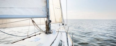 Açık denizde, açık bir günde beyaz bir yat. Güverteden pruvaya kadar tepeden aşağı görüş, direk ve yelkenler, ekipmanları yakın çekim. Yaz Atlantik 'i İspanya ve Afrika yakınlarında geçiyor.